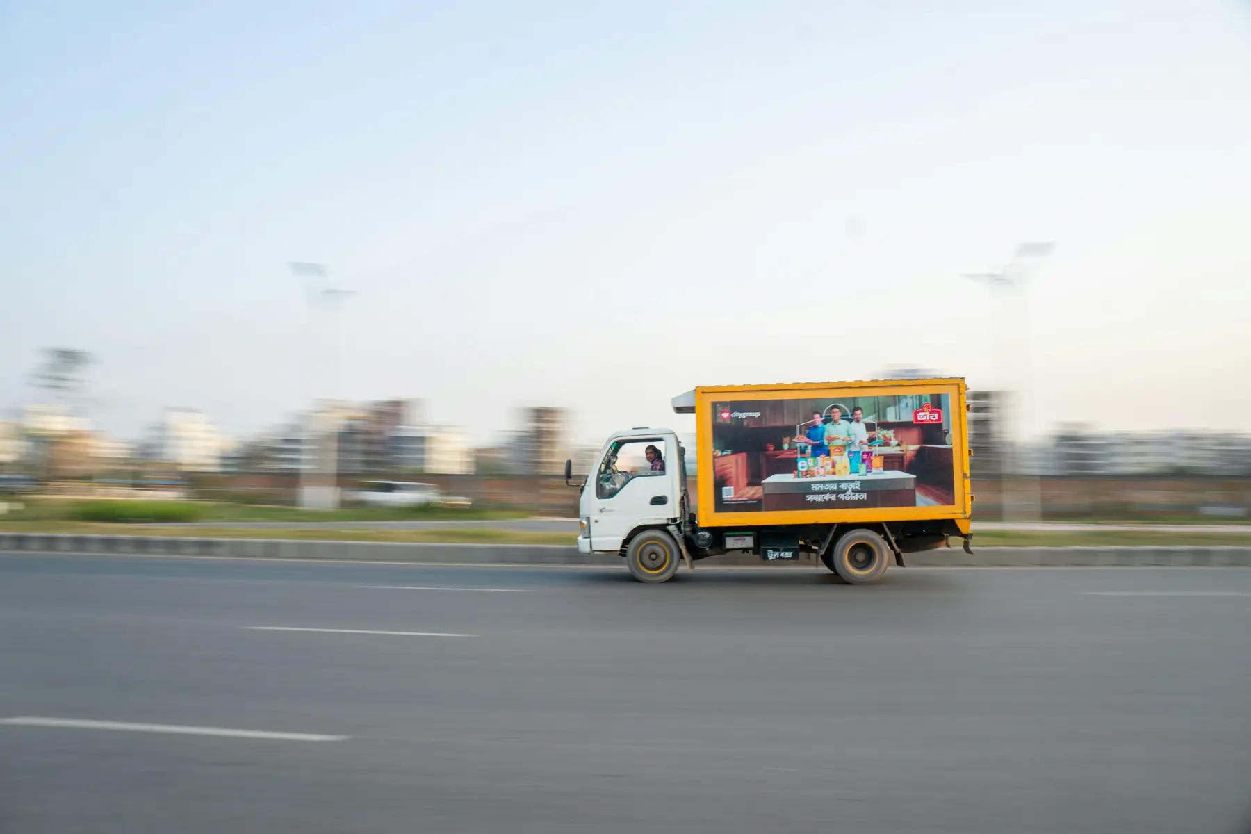 Home Delivery truck travelling on a road in Dhaka, Bangladesh